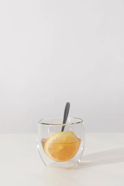 Glas Mit Frischem Kräutertee Löffel Und Zitronenscheibe Auf Grau — Stockfoto