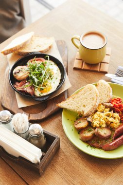 Breakfast with fried eggs served and coffee on table clipart