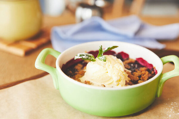 Close-up view of berry crumble served in pot with ice cream