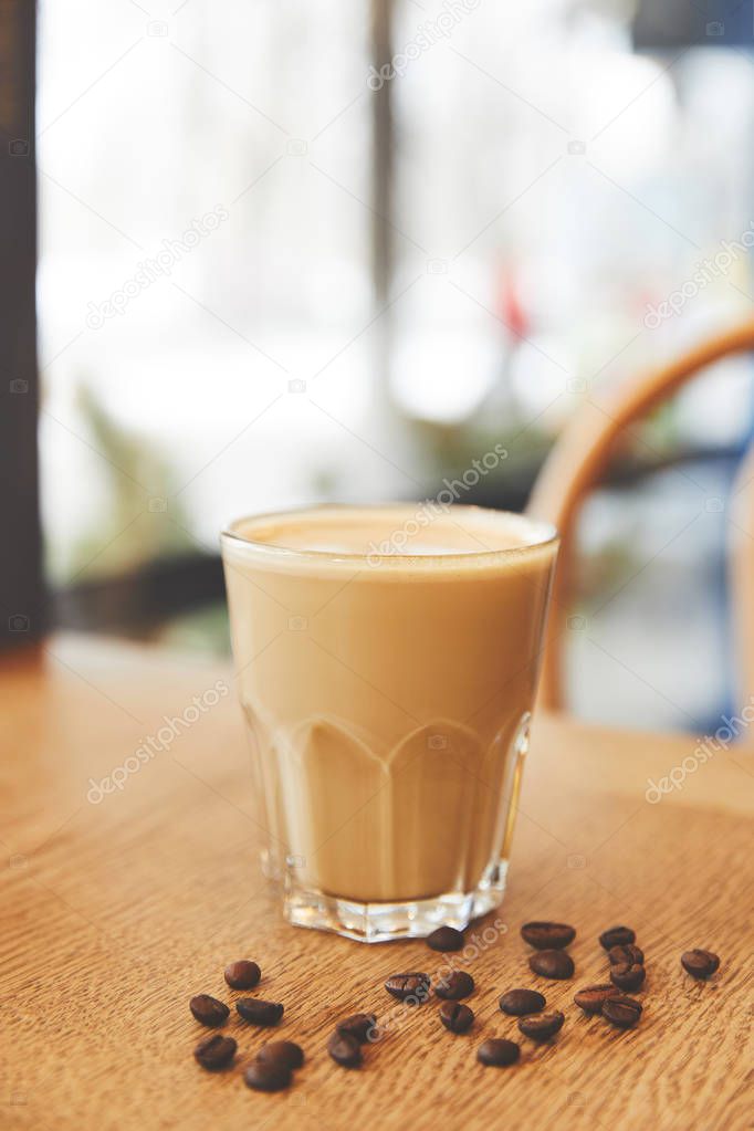 Hot flat white coffee with beans on table