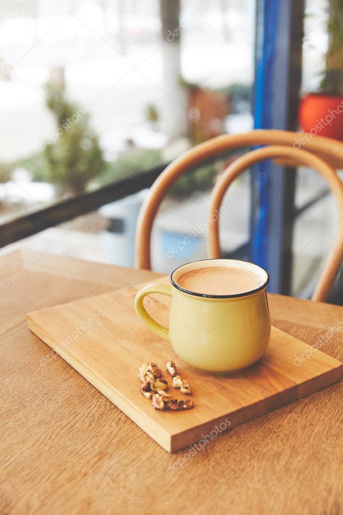 Mug with hot cocoa served with walnuts and orange peel