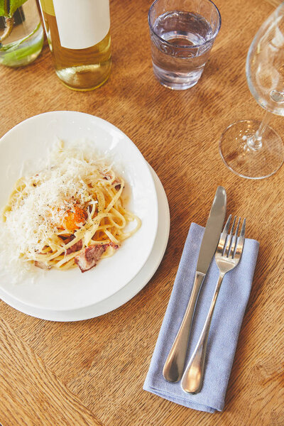 Italian carbonara pasta served with wine