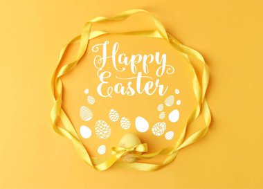 top view of yellow painted easter egg with ribbons on yellow with happy easter lettering clipart