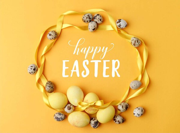 top view of yellow painted easter eggs and quail eggs on yellow with happy easter lettering