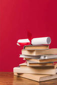 Diploma, tetején a verem a könyvek, a piros