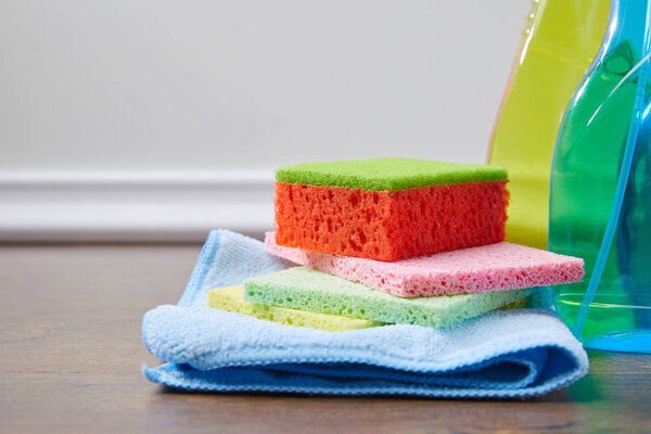 bottles with antiseptic liquids and rags for spring cleaning on wooden floor