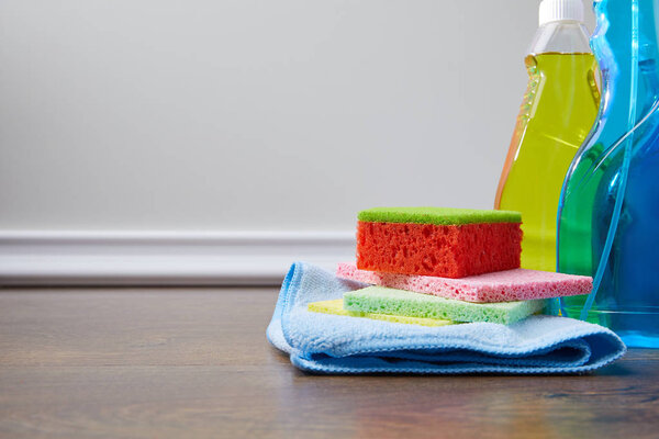 bottles with antiseptic liquids and rags for spring cleaning on floor