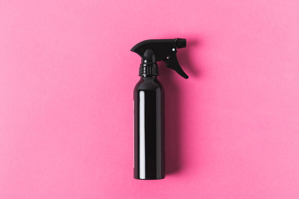 top view of black spray bottle, isolated on pink