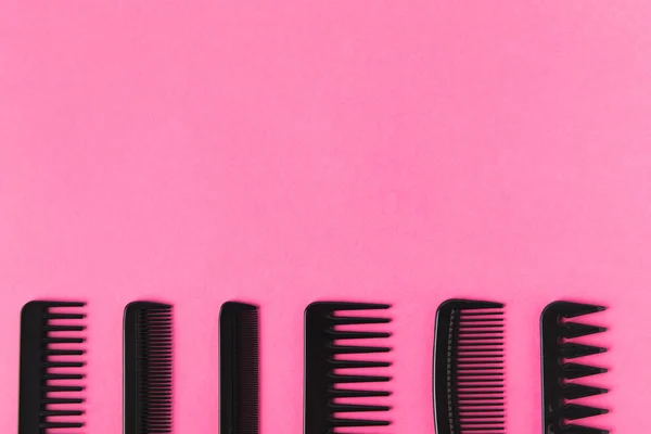 Bovenaanzicht Van Zwarte Kammen Rij Geïsoleerd Roze Met Kopie Ruimte — Gratis stockfoto