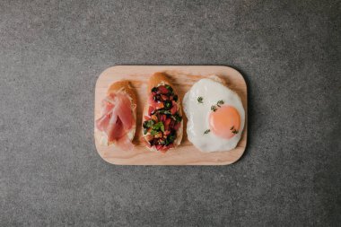lezzetli meze bruschetta kızarmış yumurta ile üstten görünüm Grey ahşap tahta üzerinde
