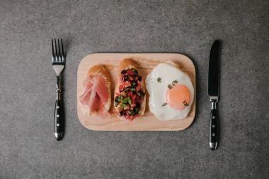Grey gurme meze bruschetta kızarmış yumurta ve çatal bıçakla Üstten Görünüm  