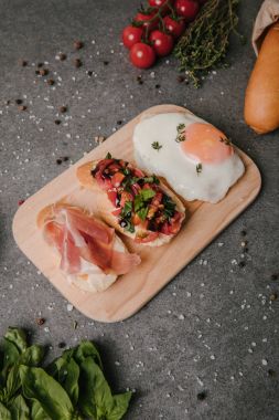 lezzetli meze bruschetta ve ahşap kesme tahtası üzerinde kızarmış yumurta ve malzemeler Grey 