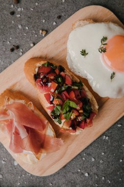 lezzetli meze bruschetta ve ahşap kesme tahtası üzerinde kızarmış yumurta ve baharatları Grey