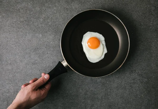 Частичный Вид Сверху Человека Держащего Сковородку Жареным Яйцом Сером — стоковое фото