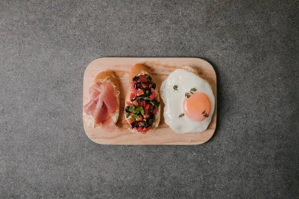 Top View Delicious Antipasto Bruschetta Fried Egg Wooden Board Grey — Stock Photo, Image