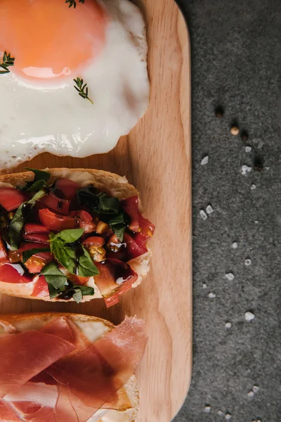 Top View Delicious Antipasto Bruschetta Fried Egg Wooden Cutting Board — Free Stock Photo