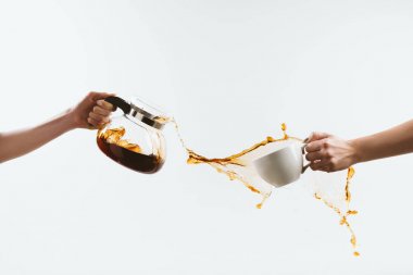 cropped view of person holding cup and glass pot with splashes of coffee, isolated on white clipart