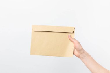 partial view of woman holding blank kraft envelope in hand isolated on white clipart
