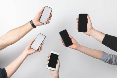 partial view of group of people with smartphones with blank screens isolated on white clipart