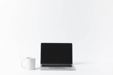laptop ile boş bir ekran ve üzerinde beyaz izole beyaz kupa görünümünü kapat