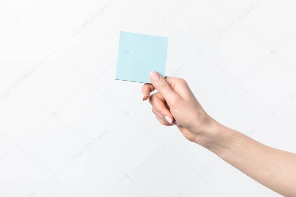 cropped shot of woman holding blank blue sticky note in hand isolated n white