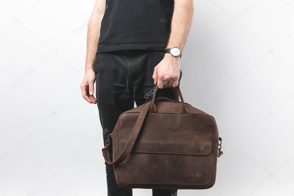 partial view of man holding leather bag in hand isolated on white