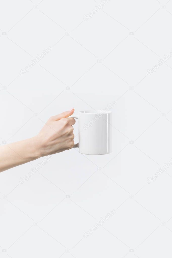 cropped shot of woman holding white mug in hand isolated on white
