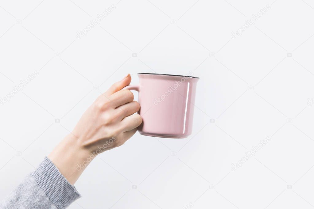 cropped shot of woman holding pink mug in hand isolated on white