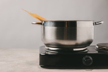 close-up shot of spaghetti boiling in stewpot on concrete tabletop clipart