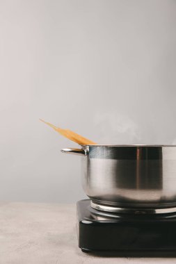 delicious spaghetti boiling in stewpot on concrete tabletop clipart