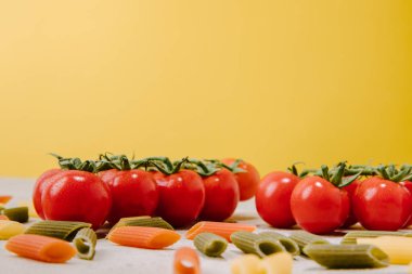 yakın çekim shot kiraz domates ve sarı çiğ renkli penne makarna