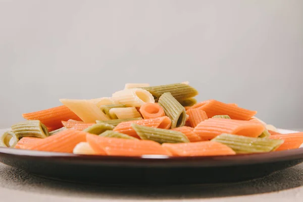 Nahaufnahme Bunter Pasta Auf Teller Auf Betontischplatte — kostenloses Stockfoto