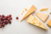 Pohled shora z různých druhů sýrů a hrozny na bílém 