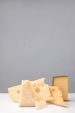 Closeup view of different types of cheese on gray clipart