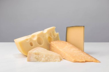 Closeup view of different types of cheese on gray clipart