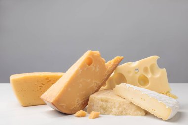 Close up shot of different types of cheese on gray clipart