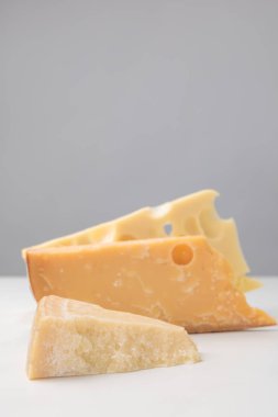 Close up shot of different types of cheese on gray clipart