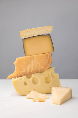 Close up view of stack of different types of cheese on gray clipart