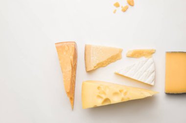 Top view of different types of cheese on white  clipart