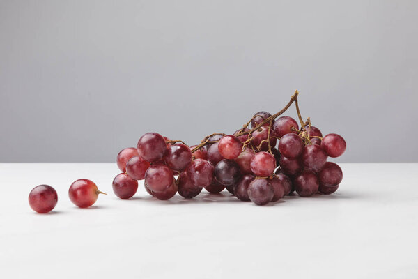 Close up view of pile of red grapes on gray 