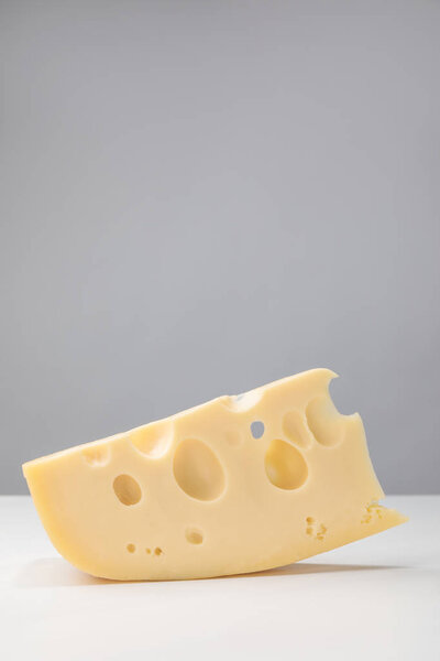 Close up image of maasdam cheese on gray