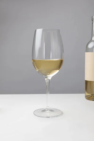 Nahaufnahme Von Weißweinglas Und Flasche Auf Grau — Stockfoto