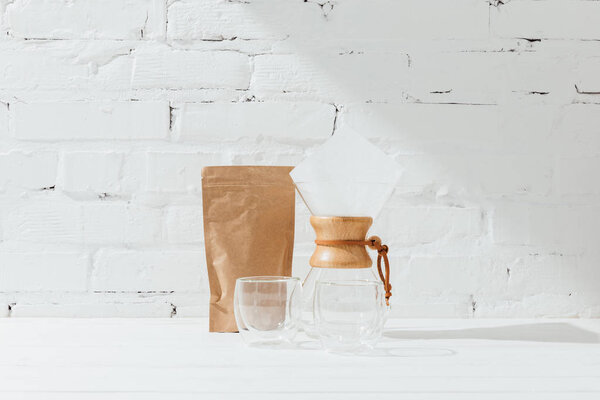 Glass mugs, chemex and paper package with coffee 