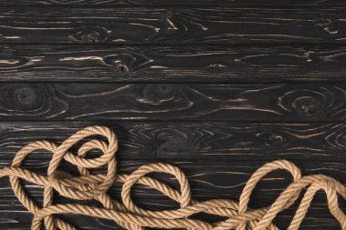 top view of brown marine rope on dark wooden planks clipart