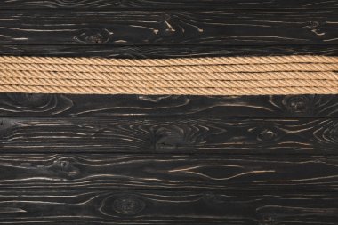 top view of brown nautical ropes placed in row on wooden background clipart