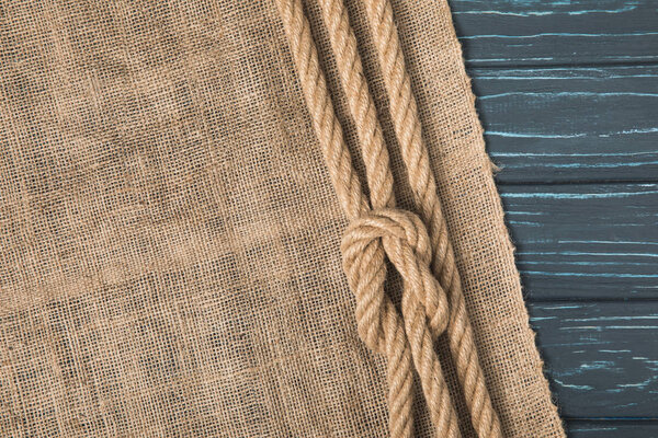 top view of brown nautical rope with knot on sackcloth 