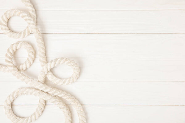 top view of white nautical rope on wooden surface