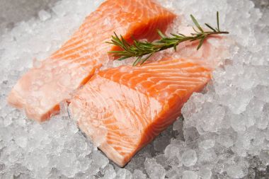 close-up shot of sliced salmon with rosemary branch on crushed ice clipart