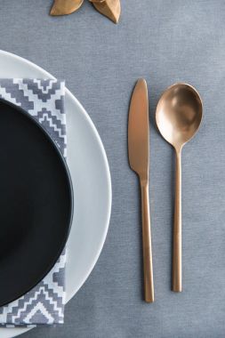Masa üzerinde siyah boş levha, peçete ve eski moda kararmış çatal Üstten Görünüm