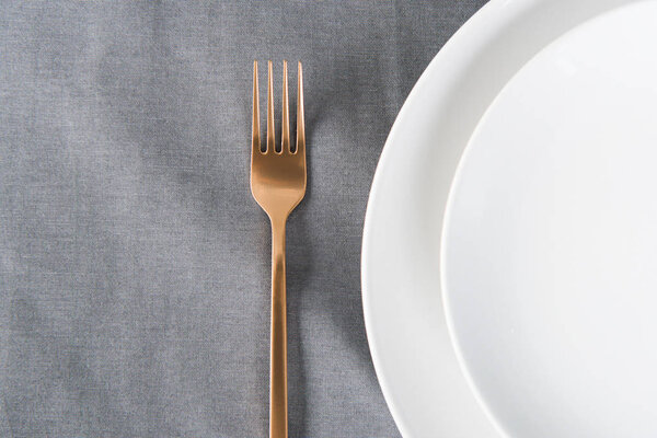top view of arranged tarnished old fashioned fork and empty plates on tabletop